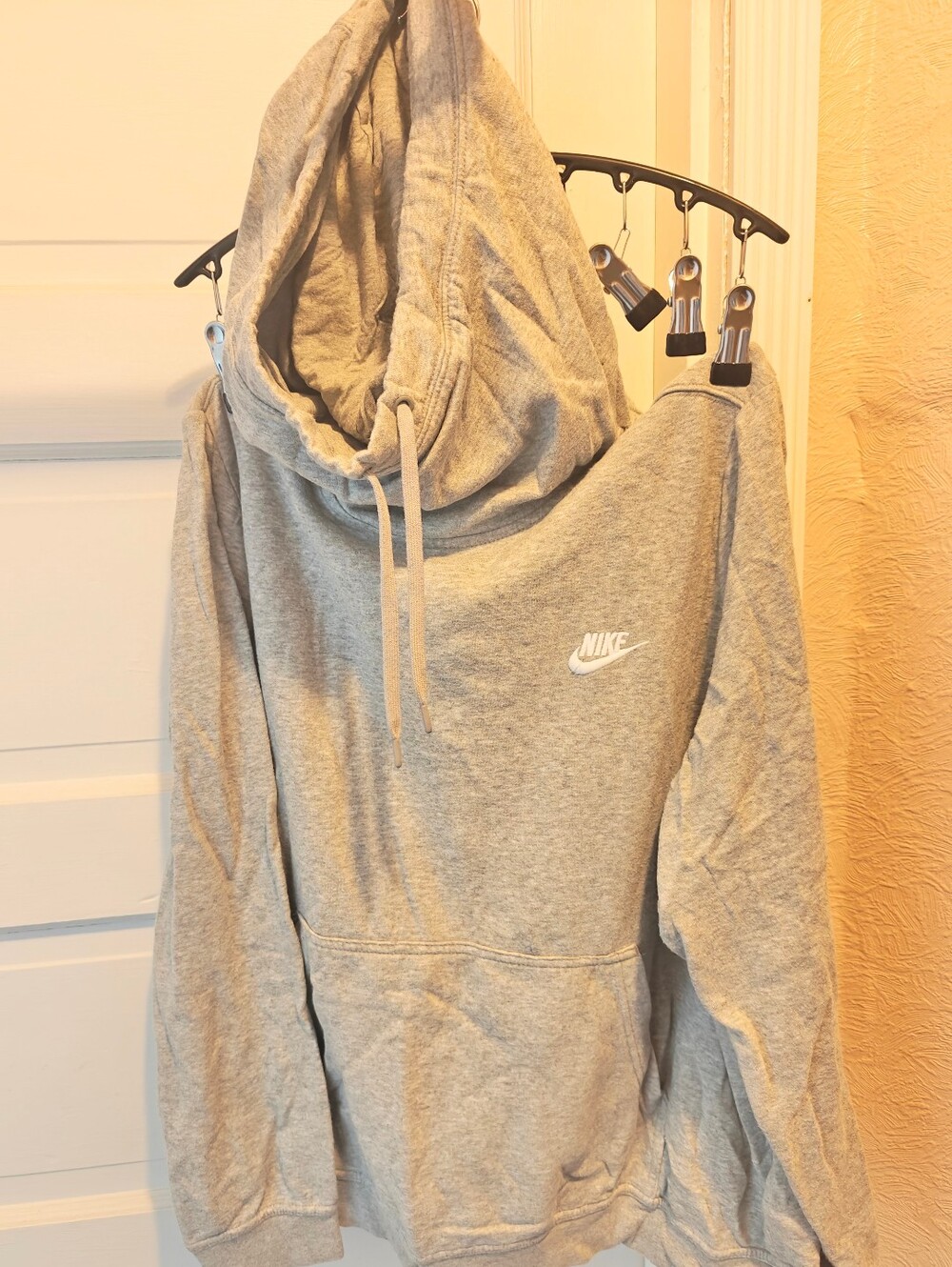 A heather grey Nike pullover hoodie with a cozy funnel neck and a white embroide